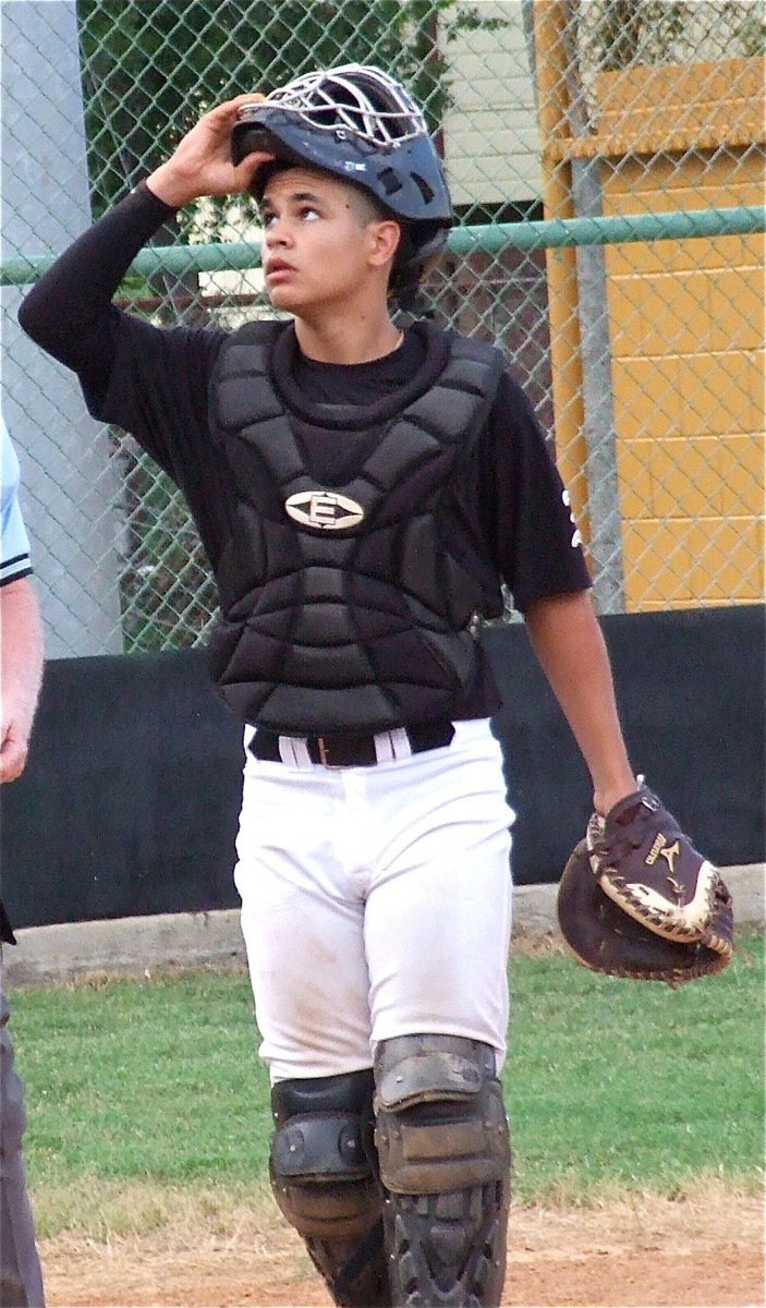 Image: Gladiator senior Reid Jacinto(5) make certain a foul ball is out of play.