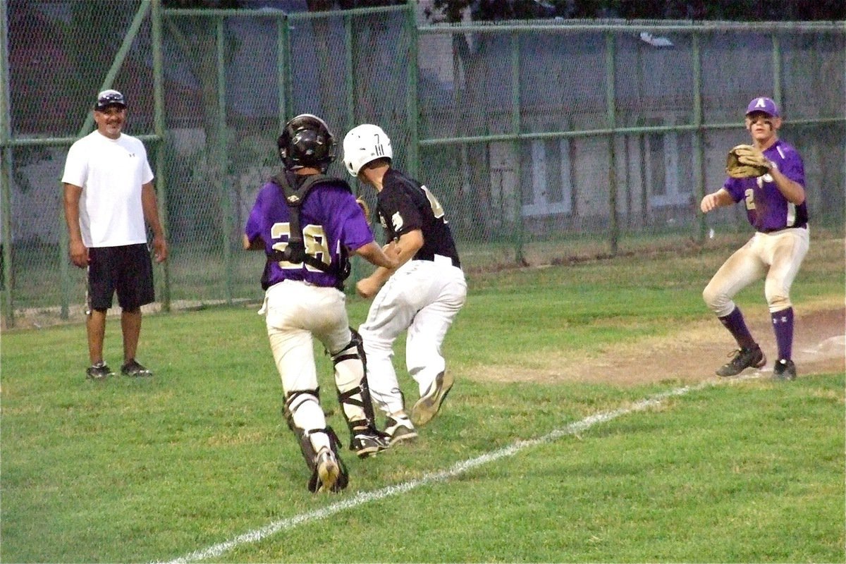 Image: Italy’s Coach Mark Jacinto is unable to hide his grin as Justin Wood(4) gets trapped in a run down between third and home. Wood was out by a shoelace trying to return to third base.