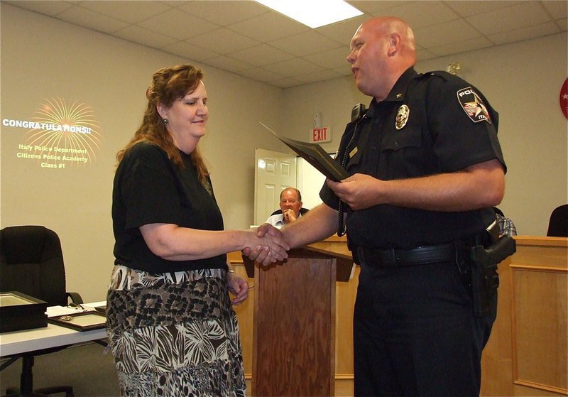 Image: Meg Lyons graciously accepts her diploma from Italy Police Chief Diron Hill as a member of the first graduating class of the Citizens Police Academy.