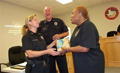 Image: Elmerine Allen Bell presents Officer Tierra Mooney with a gift for Officer Kilo, the department’s canine cop. Elmerine explained, “I hope the gift helps Officer Kilo to like me,” which got a chuckle from Chief Hill and the attending guests.
