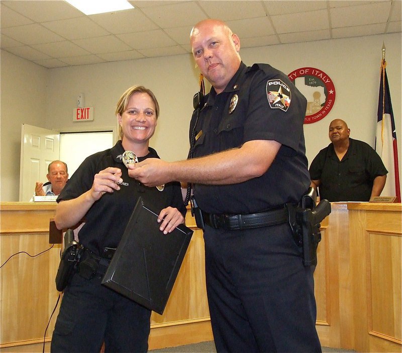 Image: Congratulations to newly promoted Sergeant Tierra Mooney of the Italy Police Department who is pictured receiving her Sergeant’s badge and a framed certificate from Chief Diron Hill as Mayor Frank Jackson and city council members look on.