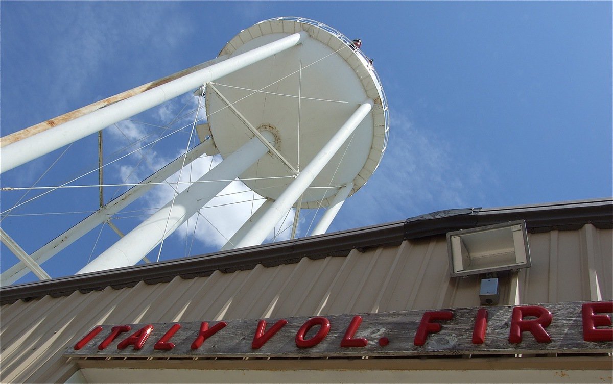 Image: The Italy Water Tower stands directly behind the Italy Fire Department and shadows downtown Italy.