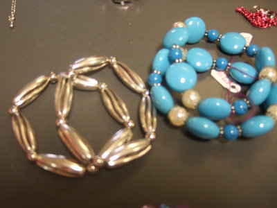 Image: Bracelets, one in gold tone and one in turquoise color.