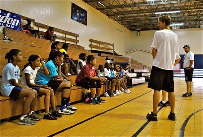 Image: Camp coaches talk with Basketball Smile campers during a break in the action.