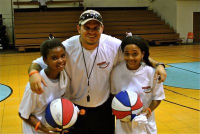 Image: Andrew Harlow, Prosper High School alumni and football stand-out, football player at Hardin Simmons University, and a camp Basketball Smiles coach, autographs basketballs for campers who were excited to receive their very own basketballs for the first time in their young careers.