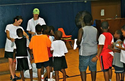 Image: Basketball Smile campers lineup to receive their camp T-Shirts.