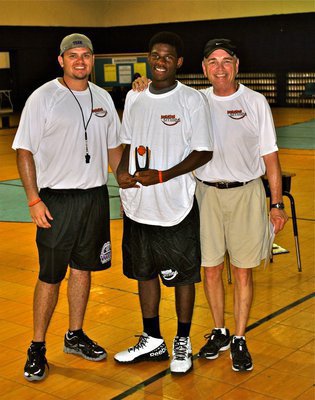 Image: Andrew Harlow and Sam Nichols present a Basketball Smiles trophy to a deserving camp participant.