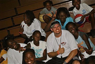 Image: Andrew Harlow relates well to the Basketball Smiles campers as they smile for the camera.