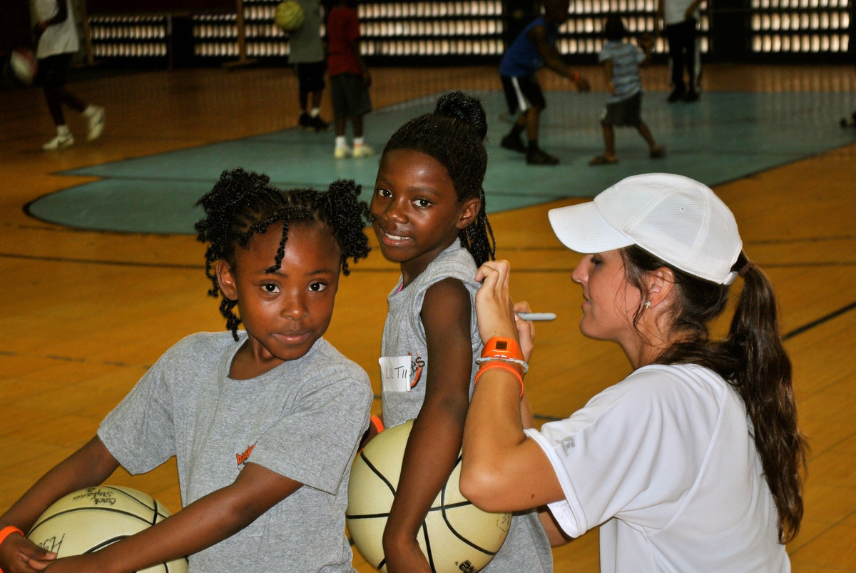 Image: Megann Mae Lewis Harlow autographs T-Shirts for a couple of Basketball Smiles campers who are big fans of their coach.