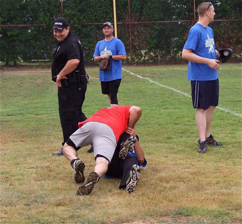 Image: A pre-game disturbance breaks out when Italy Firefighter Jackie Cate jokingly attacks Italy Police Department team member Rodney Guthrie in a friendly brawl.