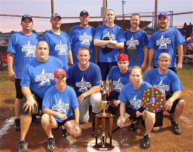 Image: The Italy Police Department poses with the official Guns Vs. Hoses trophy that will travel between departments each year depending on which side wins the game. Back row: DPS Trooper Vance Griffin, Officer Shawn Martin, Chief Diron Hill, Officer Michael Richardson, Citizens Police Academy member Kelly Westbrook, Police Commissioner Rodney Guthrie. Middle row: Ellis County Constable Brad Elliott, Bryan Police Officer Robert McFarland, Officer Daniel Pitts and Criminal Investigator Perry Kaemerling. Bottom row: Sergeant Tierra Mooney, the Guns Vs. Hoses trophy and Officer Shelbee Landon.