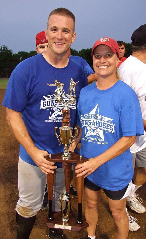 Image: Officer Bobby McFarland and Sergeant Tierra Mooney pose together with the Guns Vs. Hoses trophy.