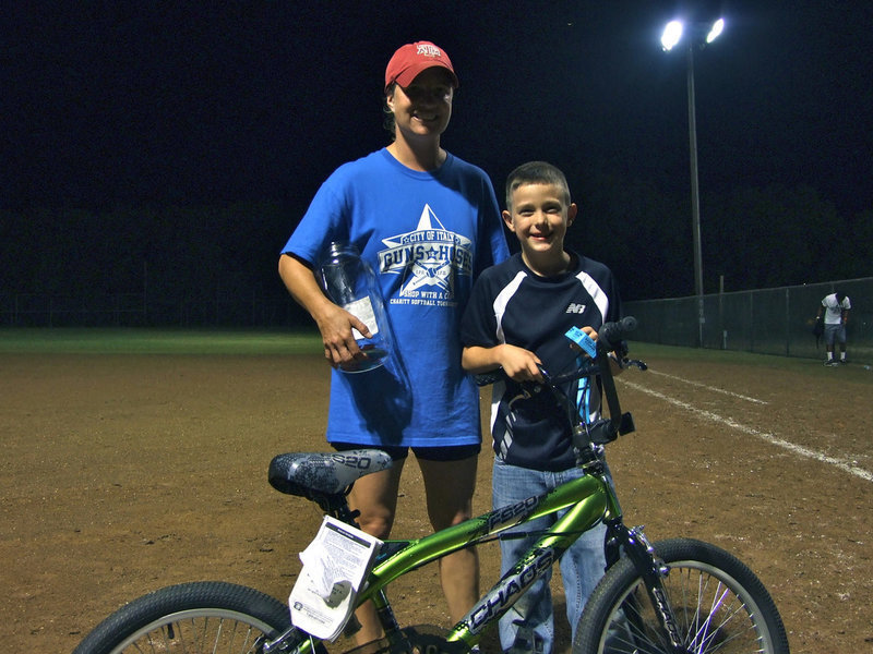 Image: Preston Turbeville, almost 9 years old, won the bicycle in the raffle.  Here Sgt. Mooney hands it over to the eager young man.