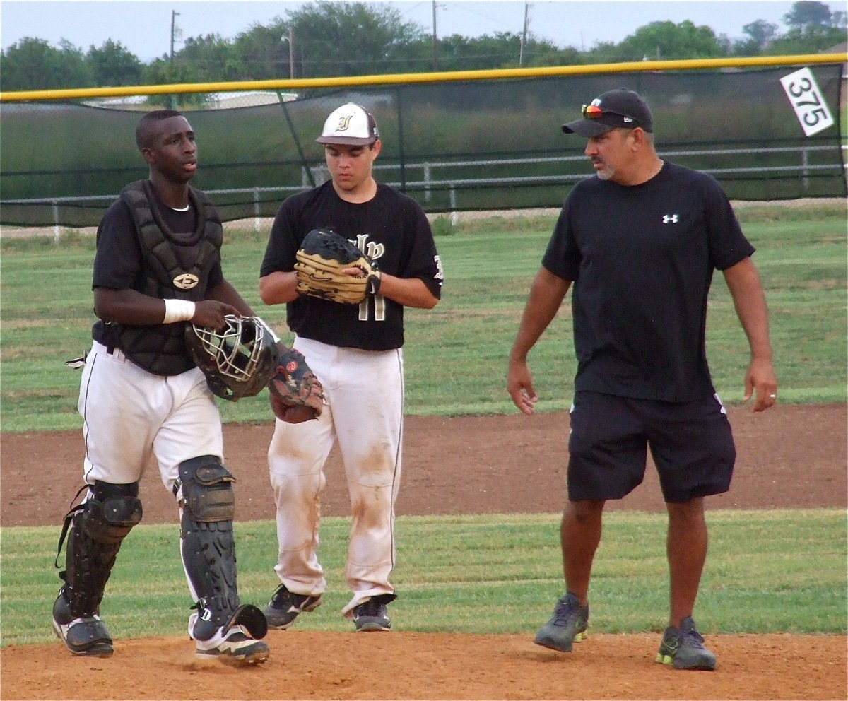 Image: Coach Mark Jacinto checks on his hurler Tyler Anderson along with catcher Marvin Cox.