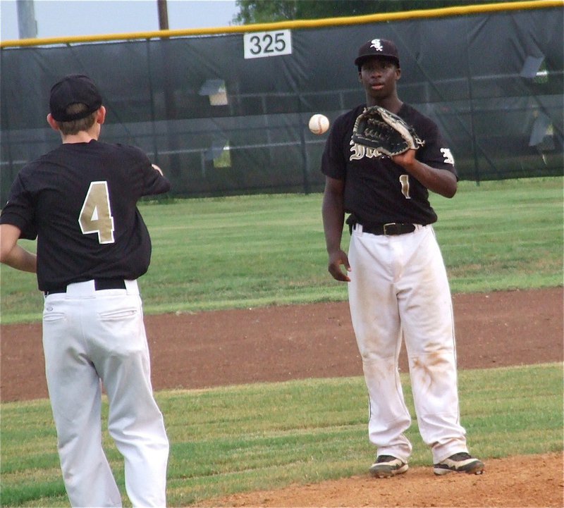 Image: Justin Wood(4) gets the ball into pitcher Marvin Cox(1) as Cox tries to rally Italy to a game two win from the mound.