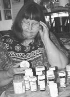 Image: Meals-on-Wheels client Mary Ellen Bryant looks over the numerous medications she takes on a daily basis.