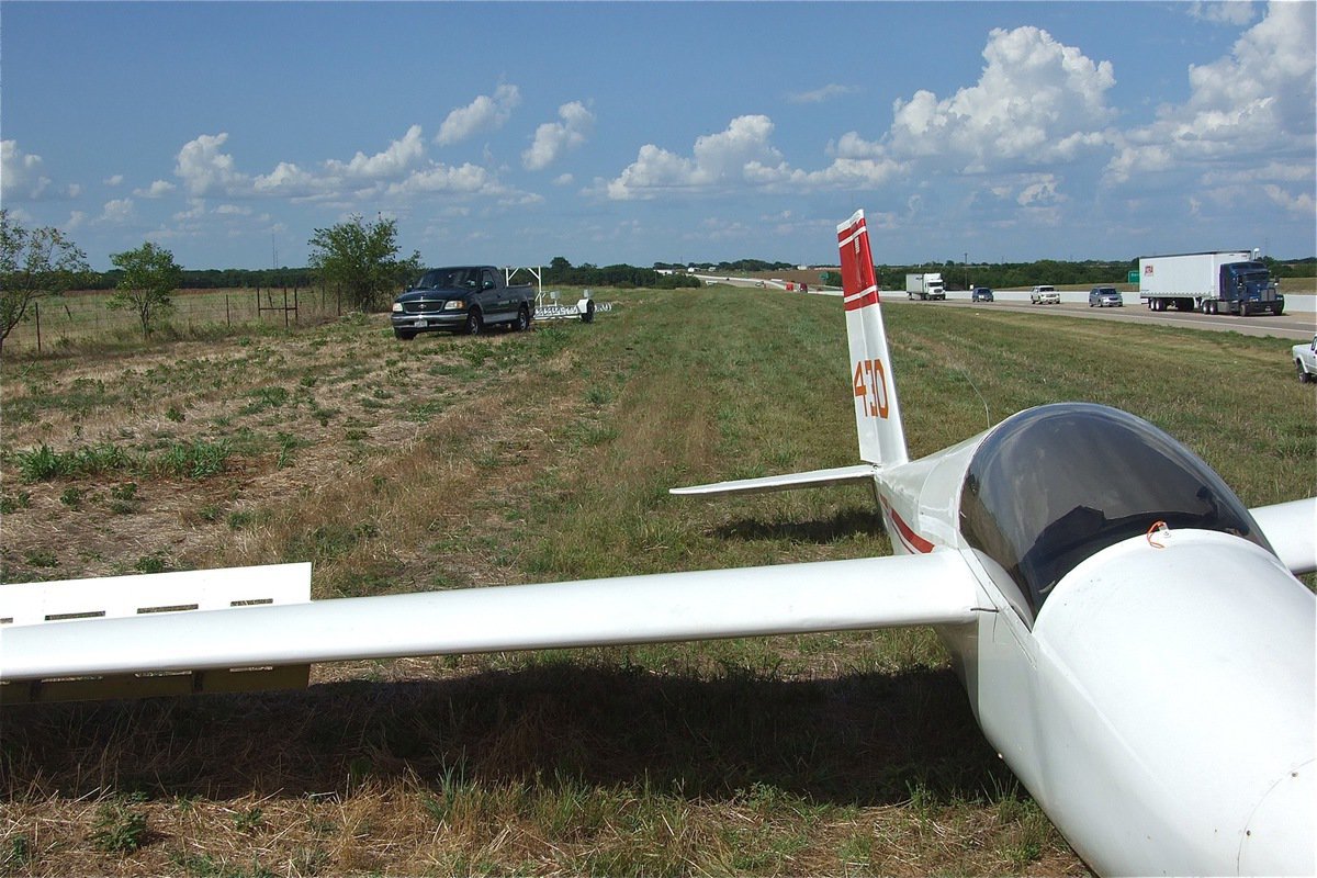 Image: Alan Fairbairn, the father of the pilot, and Mike Weatherford arrive on scene to help dismantle and tow the glider back to the airport.