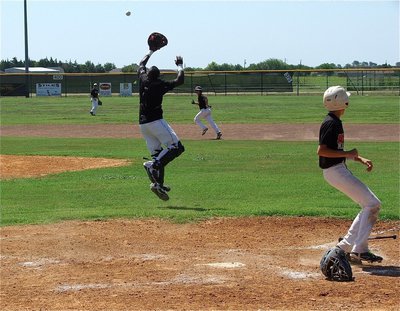 Image: Catcher Marvin Cox leaps for the catch as Italy tries to halt Mexia runners after a Blackcat hit.