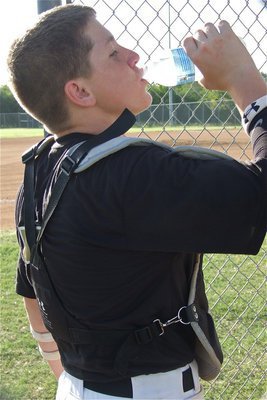 Image: John Escamilla hydrates before starting the game as Italy’s catcher.