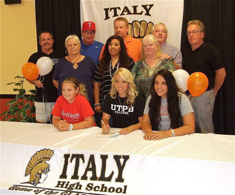 Image: Megan Richards sports her UTPB Falcon shirt during the signing with her family. Supporting Megan on her special day are: Back row – Ron Withee (Megan’s Kruzers Gold select softball coach), Jerry McGinnis (Megan’s pitching coach), father Allen Richards, grandfather Greg Richards and IHS Superintendent Barry Bassett. Middle row – grandmother Rita Garza, mother Tina Richards and grandmother Elaine Richards. Bottom row – Sister Brycelyn Richards, the newest UTPB Falcon Megan Richards and sister Alyssa Richards.