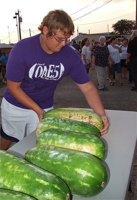 Image: Gladiator Colin Newman helps layout watermelons for the community to enjoy.