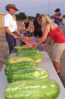 Image: Italy ISD School Board Member Curtis Riddle and Angela Janek, a 5th grade ELAR teacher for Italy’s Stafford Elementary, solve the problems to the universe while slicing watermelon for event guests.