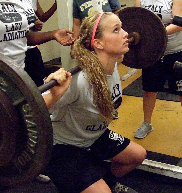 Image: Madison Washington, a sophomore, uses good form to raise the weight.