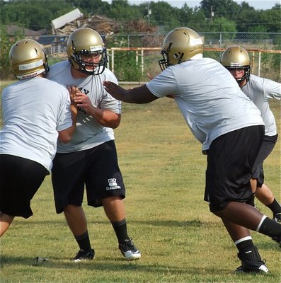 Image: Varsity offensive lineman Zackery Boykin and Adrian Reed get a look from JV players Colin Newman and Kyle Fortenberry.
