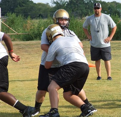 Image: Cousins Zain Byers and John Byers meet during a line blocking drill with AD/Head Coach Hank Hollywood looking on.