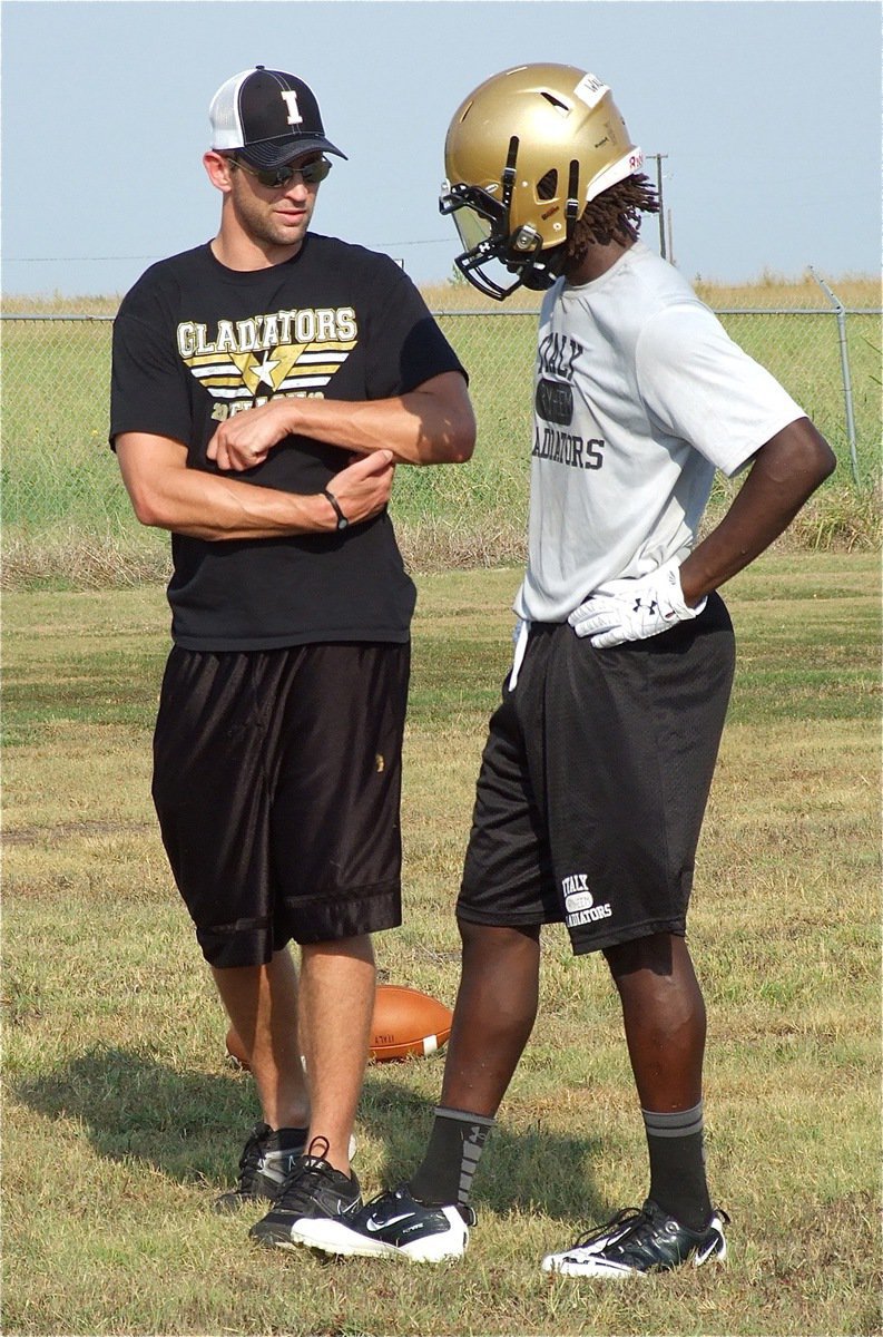 Image: Coach Nate Skelton talks technique with tailback Ryheem Walker.