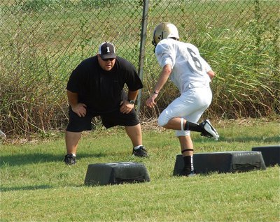Image: Senior Caden Jacinto(6) works on his defensive footwork with Coach Brian Coffman instructing.
