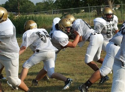 Image: Zain Byers(50) and Darol Mayberry(58) keep their owns on the backfield while practicing on defense.