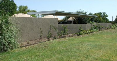 Image: A spray-in-place concrete fence adds a beautiful touch to any yard or provides privacy for your home or business. It separates and defines a yard and is a beautiful backdrop for landscaping.
