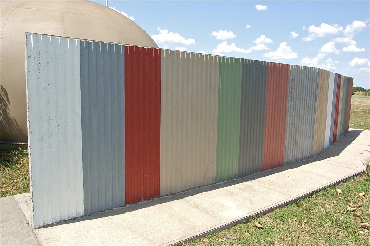 Image: Sheet metal was used to created an endless symmetrical pattern down one side of this solid concrete fence.