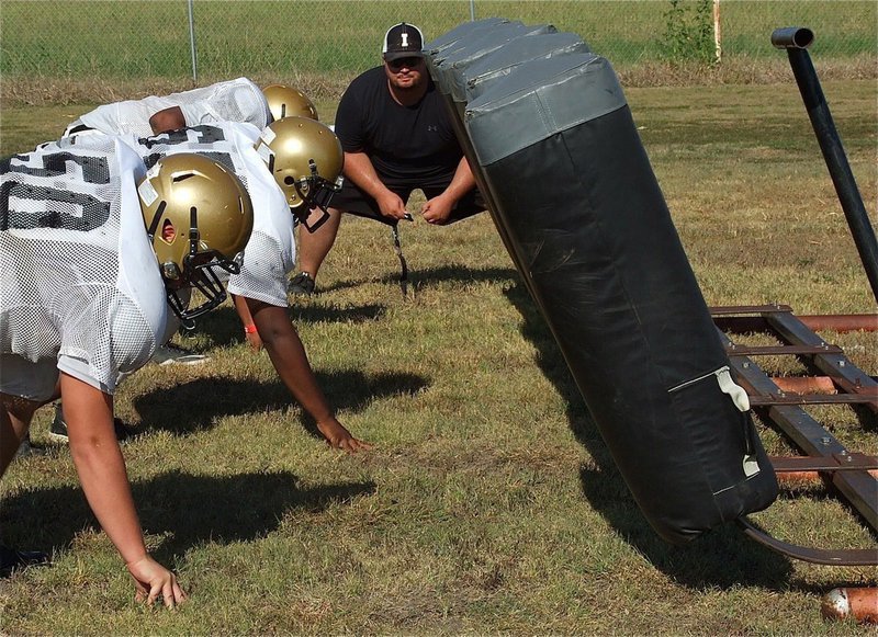 Image: Coach Brandon Duncan gets into the sled drill.