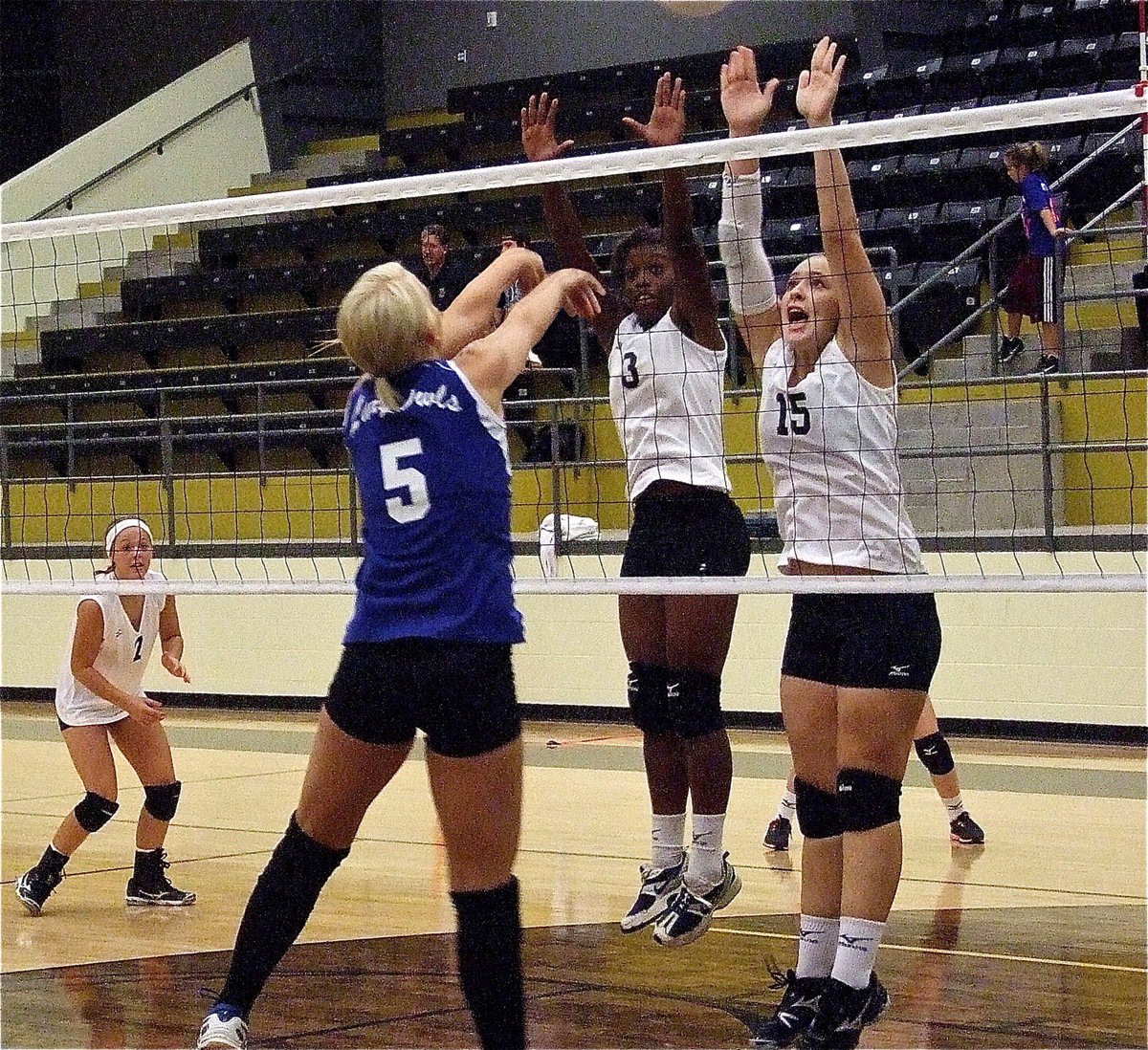 Image: Kortnei Johnson(3) and Jaclynn Lewis(15) go for the block against Covington.