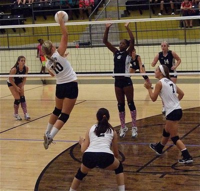 Image: Madison Washington(10) leaps high and then gets a smashing point.
