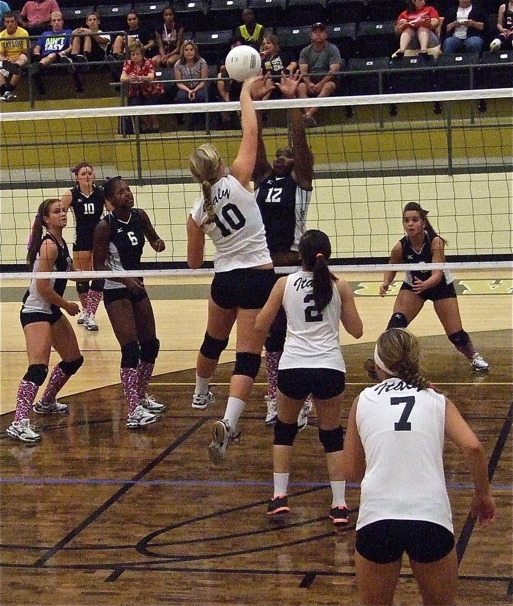 Image: Italy’s Madison Washington(10) smashes a point over the net.