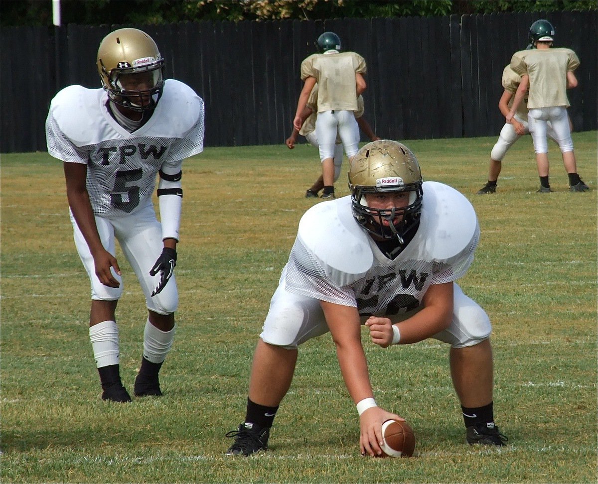 Image: Italy’s returning center Zain Byers(50) practice snaps to quarterback Eric Carson(5) before the scrimmage. Now juniors, both players were all-district performers last season as sophomores for the Gladiators.