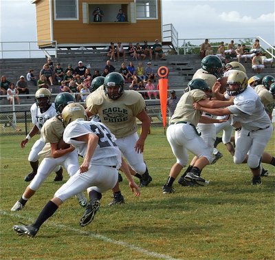 Image: Justin Wood(22), a junior, chases the Eagle quarterback out of his nest.