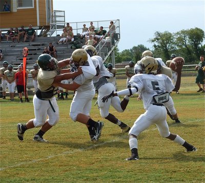 Image: Junior right offensive guard Kevin Roldan(60) gives his quarterback Eric Carson(5) time to pass.