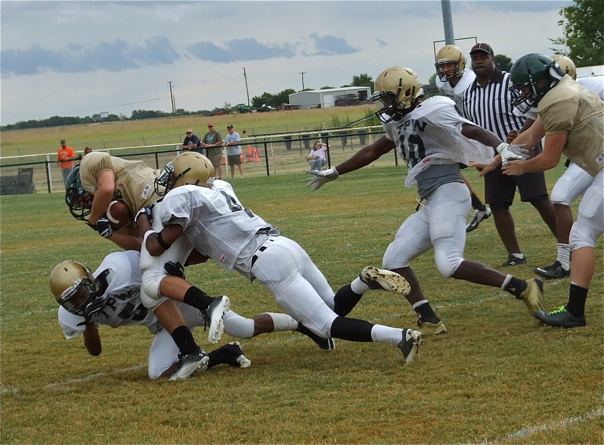 Image: Italy’s Trevon Robertson(4) and Eric Carson(5) combine to tackle a tackle an Eagle running back.