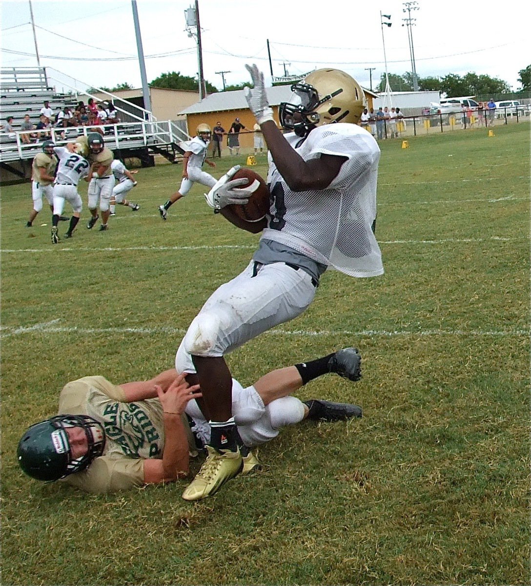 Image: Ryheem Walker(10) tries to spin away as receivers Justin Wood(22), Caden Jacinto(6) and Kelvin Joffre(80) keep blocking downfield.