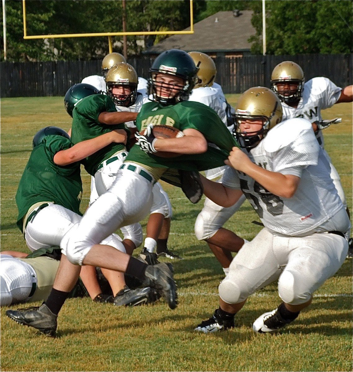 Image: The Italy JV Gladiators make a statement on the first play when left tackle John Byers(56) brings down a Valley Mills Eagle for a loss.