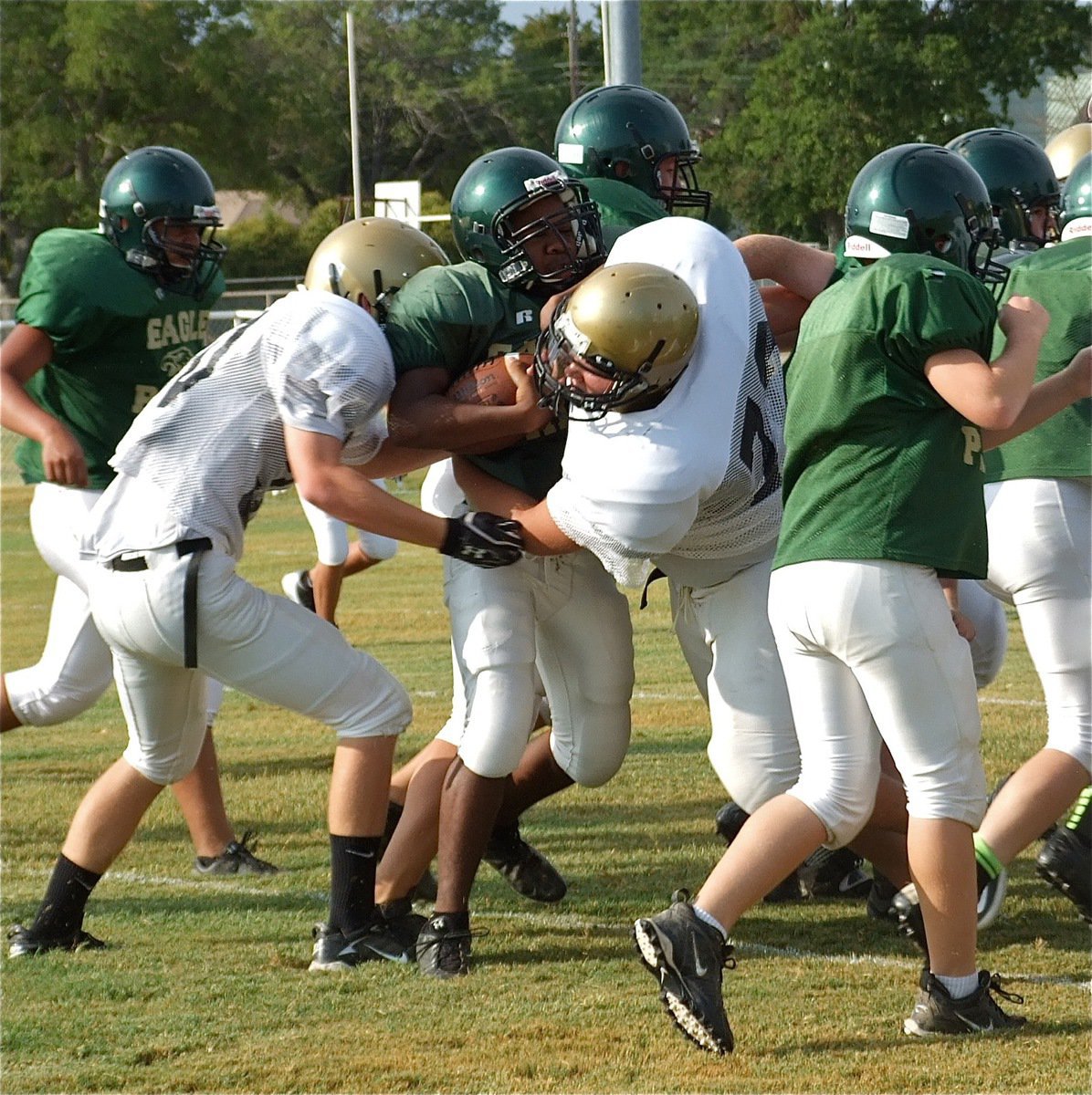 Image: Right tackle Colin Newman(72) and teammate Cody Boyd(30) bring down an Eagle runner at the line of scrimmage.