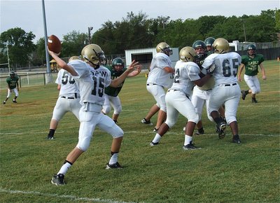 Image: JV quarterback Ryan Connor(15) gets protection from his fullback and offensive line and completes a pass downfield to receiver Levi McBride.