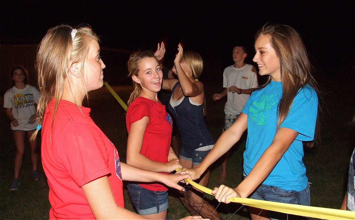 Image: Hannah Washington, Britney Chambers and Jozie Perkins give Halee Turner some help on her return volley.