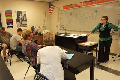 Image: Science teacher Catherine Hewett discusses course goals with students and parents.