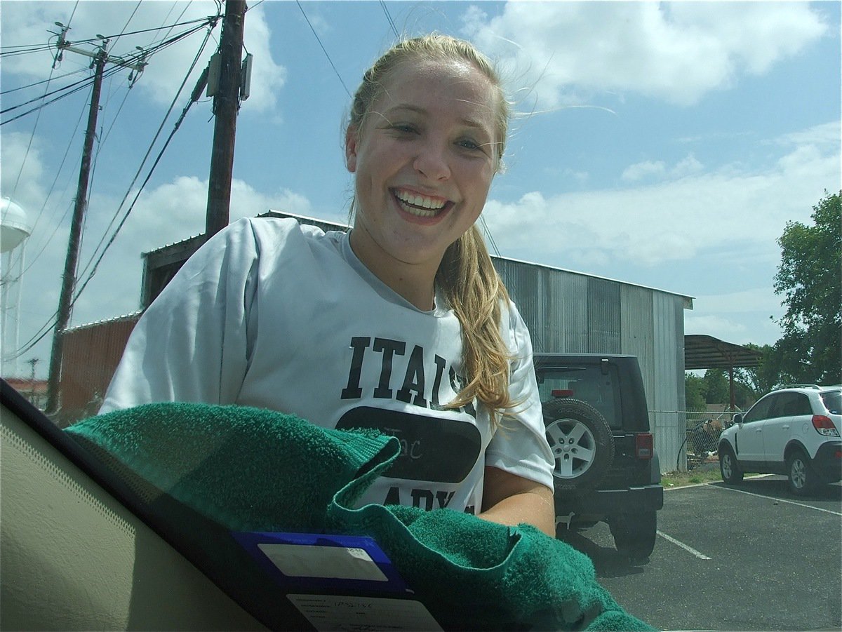 Image: Lady Gladiator Jaclynn Lewis helps to dry the cars.