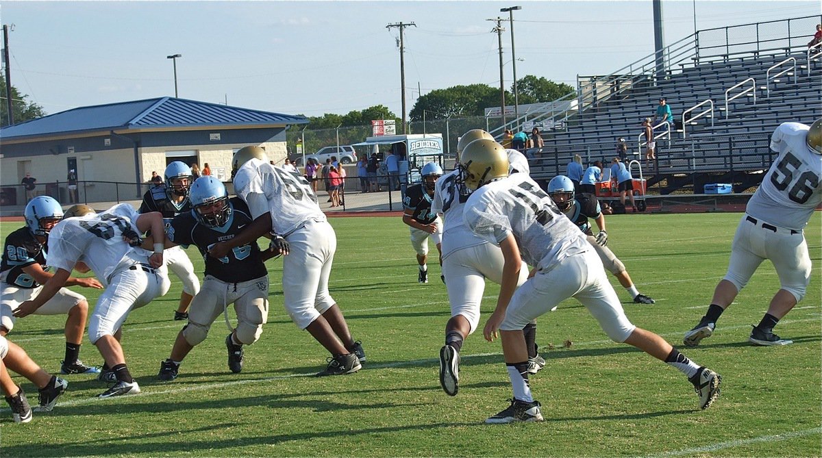 Image: Kyle Forteberry(66), Justin Robinson(65) and John Byers(56) open a running lane for the Billy “The Bus” Moore(32).